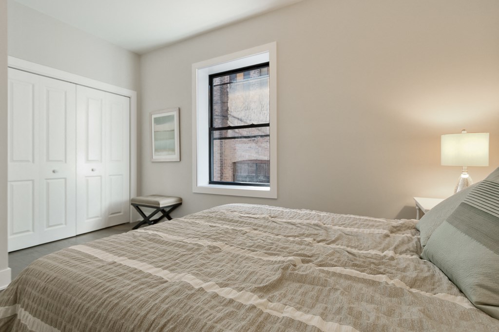 a bedroom with a large bed and a window