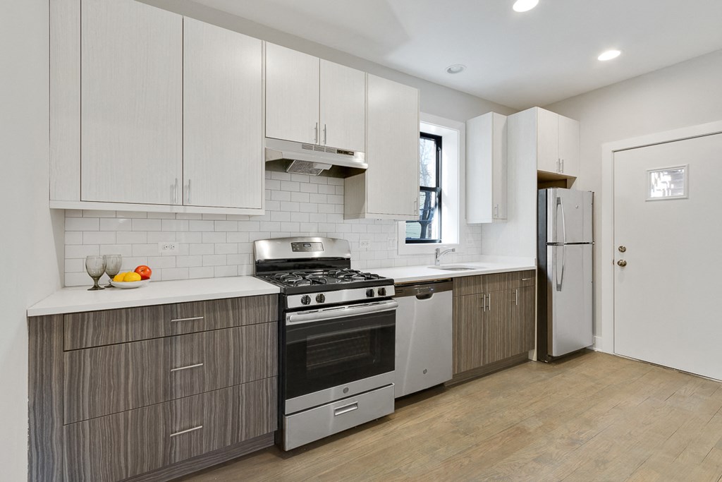 a kitchen with white cabinets and a stove and a refrigerator