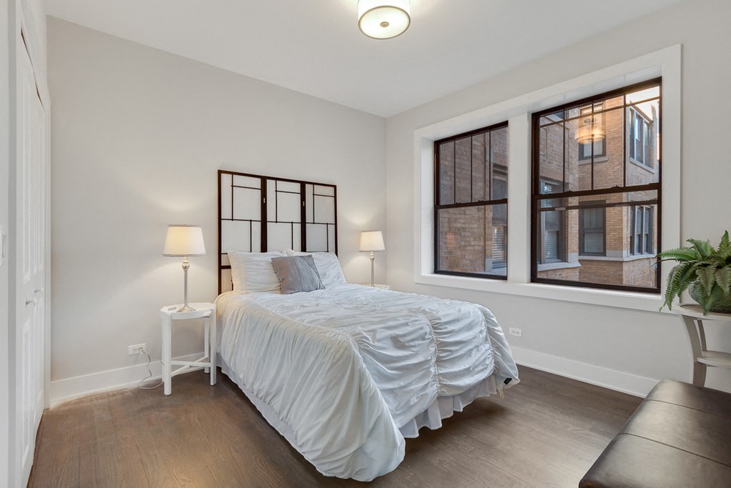 a bedroom with a bed and two windows