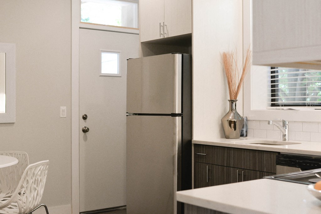 a kitchen with a refrigerator and a table and chairs