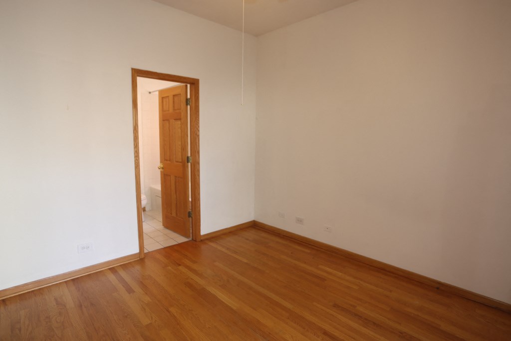 an empty living room with wooden floors and white walls