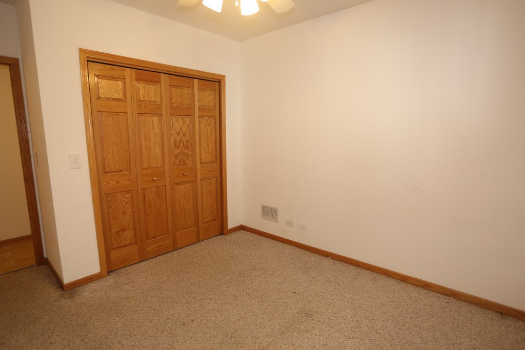 a bedroom with a closet and a door and a carpet