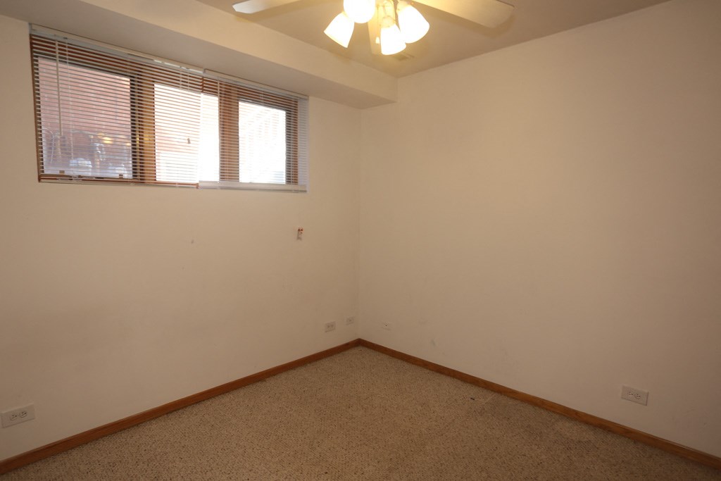 an empty room with a window and a ceiling fan