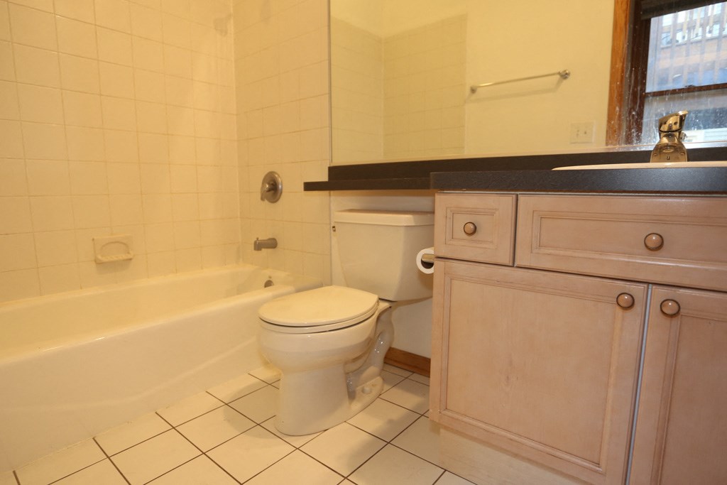 a bathroom with a toilet and a tub and a sink
