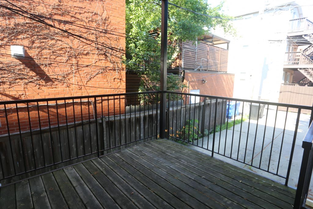 a balcony with a wooden deck and a brick building