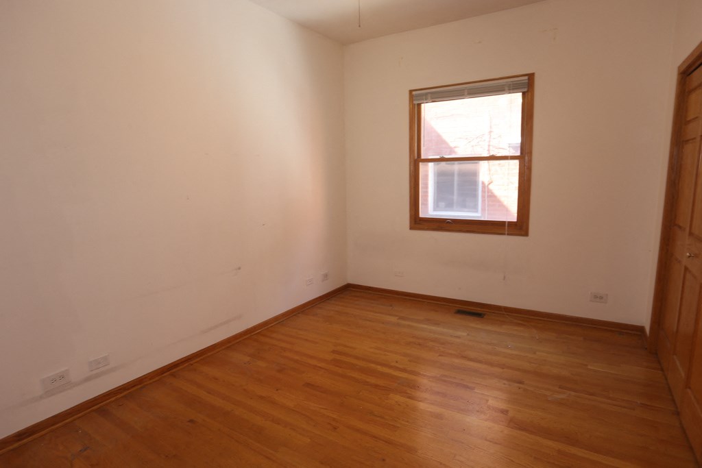an empty room with wooden floors and a window