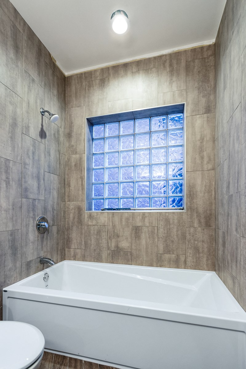 a bathroom with a tub and a shower and a window