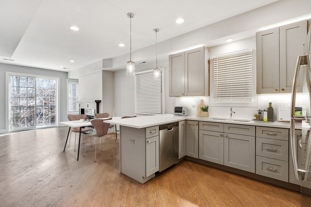 a kitchen with white cabinets and a table with a chair