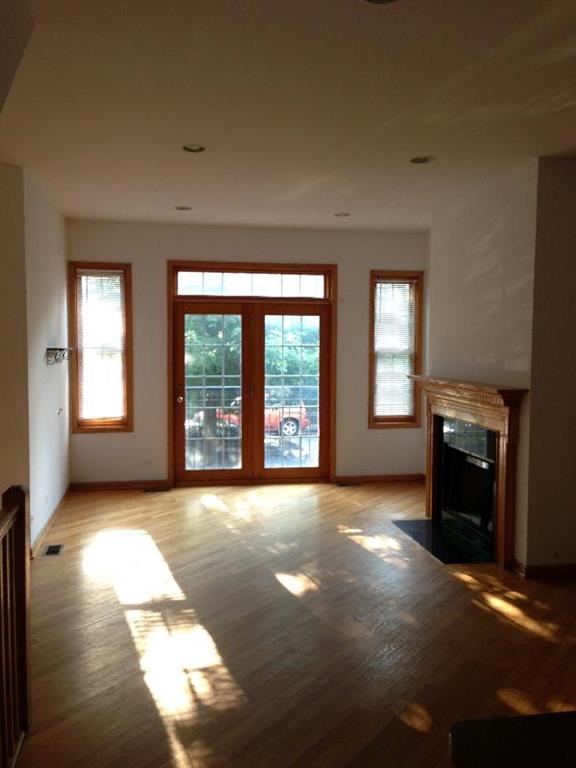 an empty living room with a fireplace and doors