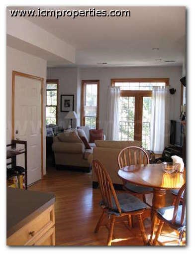 a living room and dining room with a table and chairs