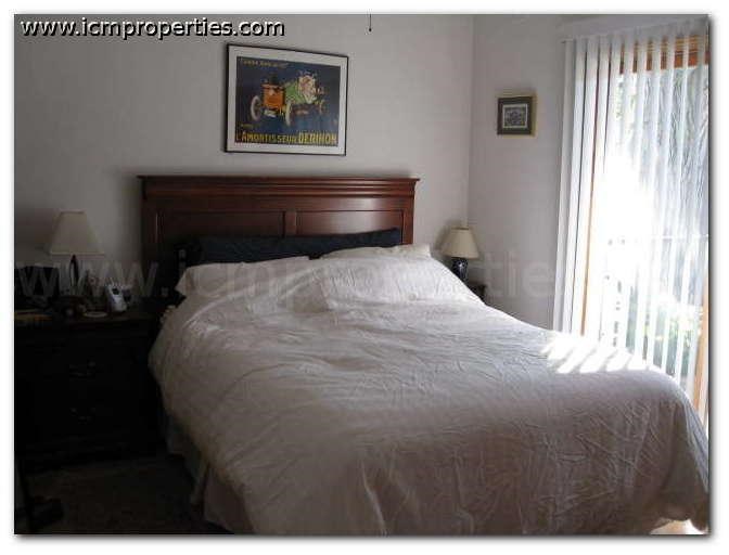 a bedroom with a white bed and a window