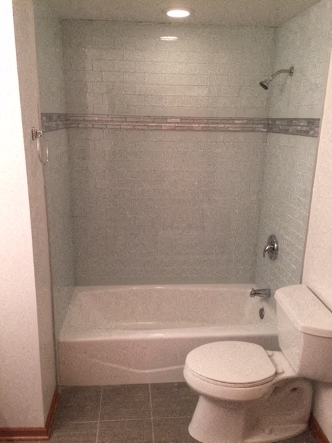 a bathroom with a white toilet and a bath tub