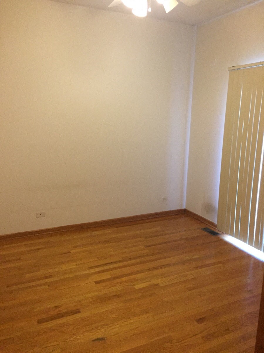 an empty room with wooden floors and a white wall