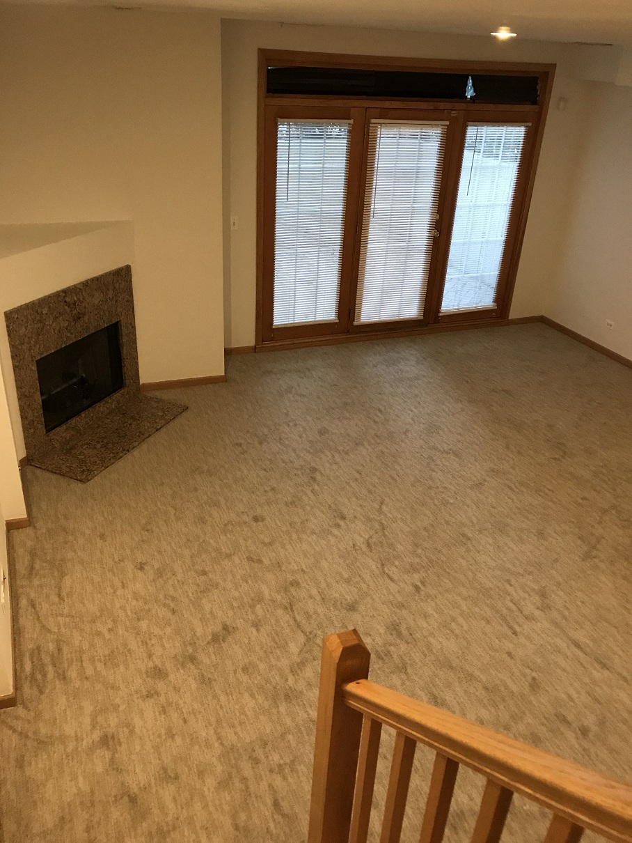 an empty living room with a fireplace and a staircase