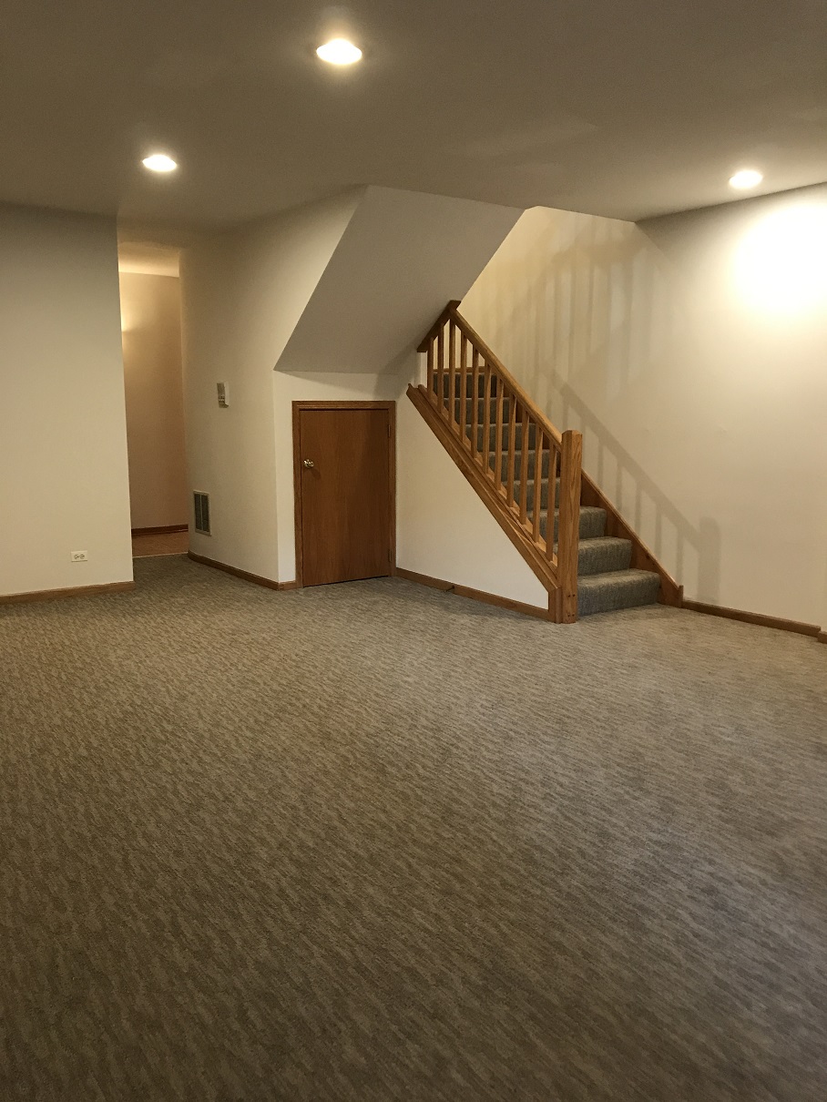 an empty living room with a staircase in a house