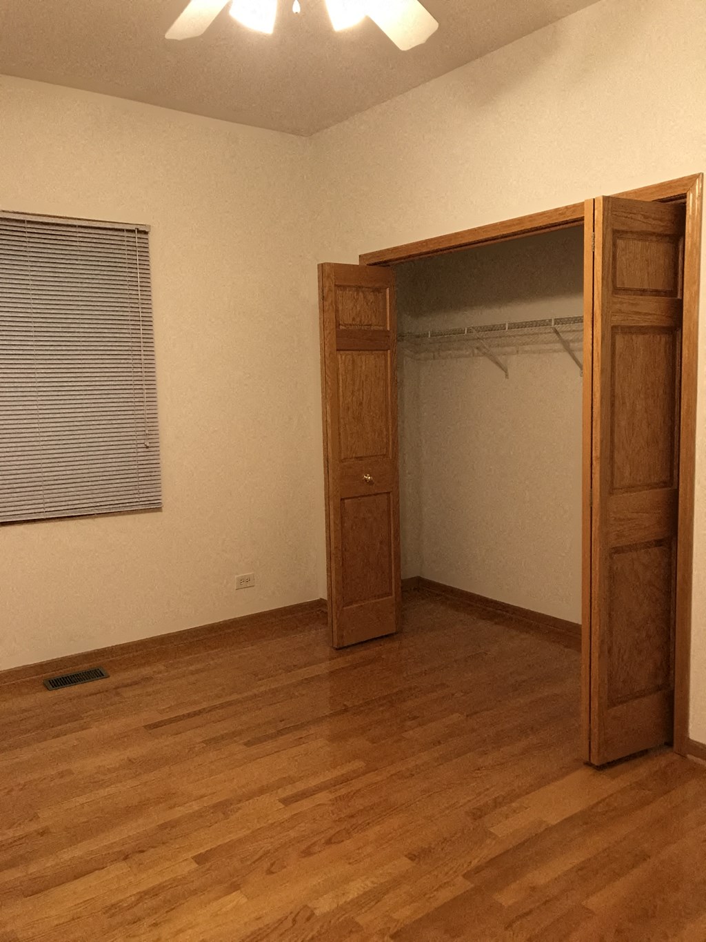 an empty room with a door open to a closet