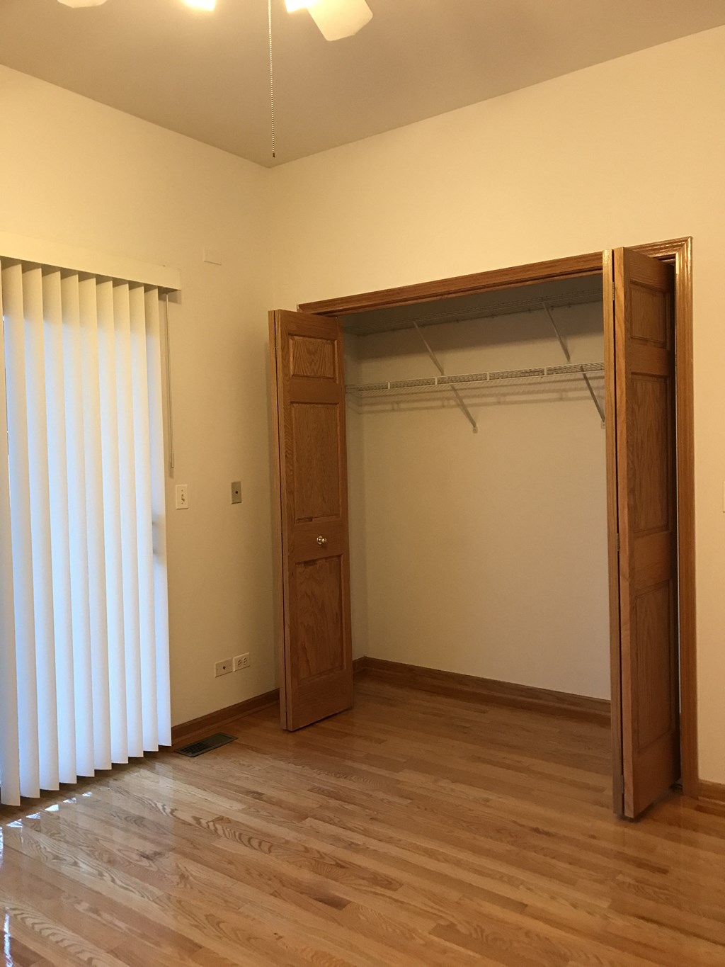 an empty room with a closet and a sliding door