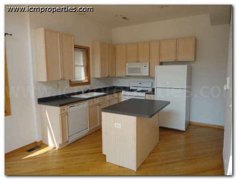a kitchen with white appliances and black counter tops