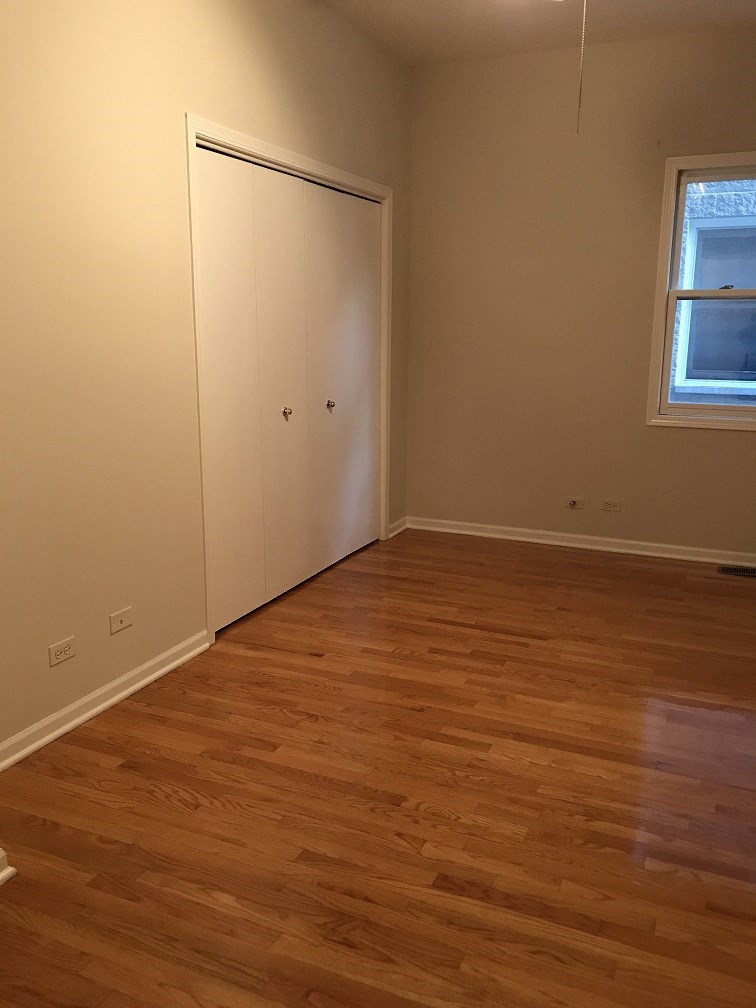 a living room with a wooden floor and a door to a closet