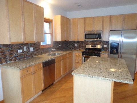a kitchen with wooden cabinets and granite counter tops