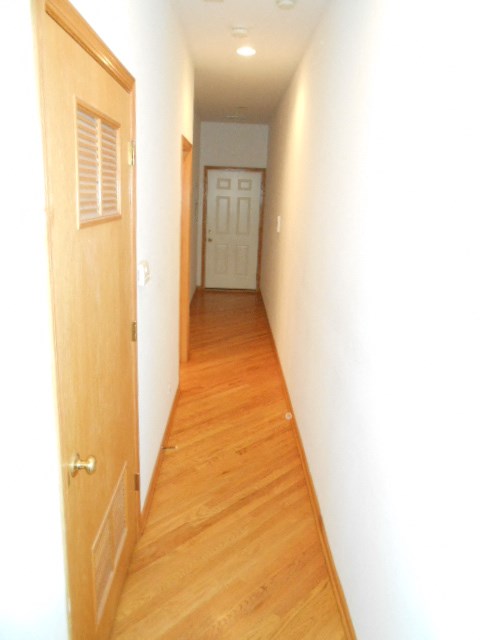 a hallway with wood floors and a white door