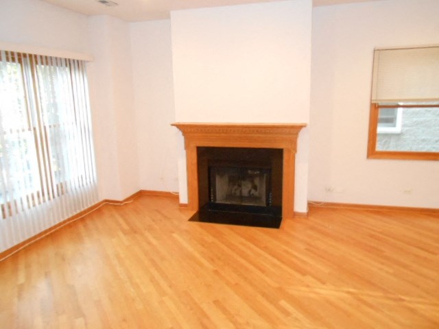 an empty living room with a fireplace and wooden floors