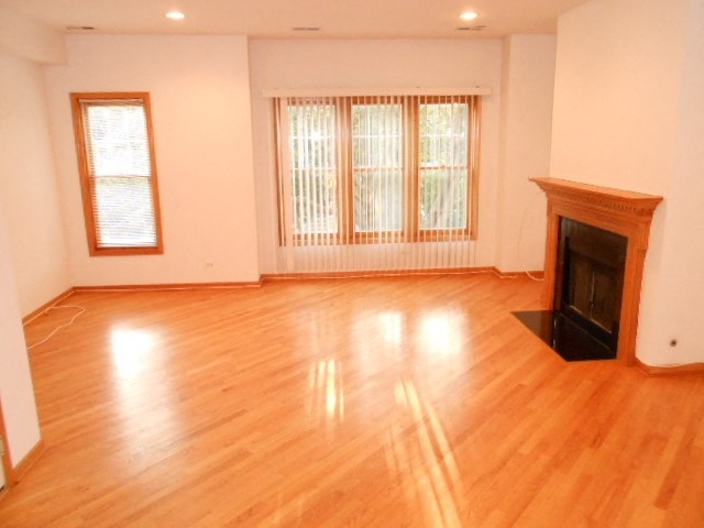 an empty living room with a fireplace and wooden floors