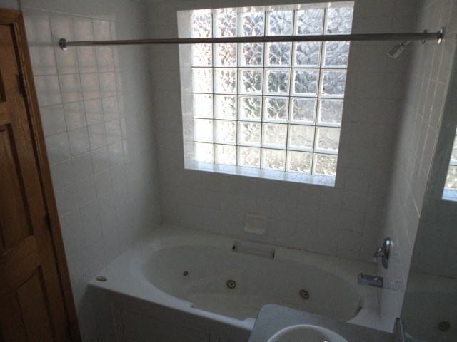 a bathroom with a jacuzzi tub and a window