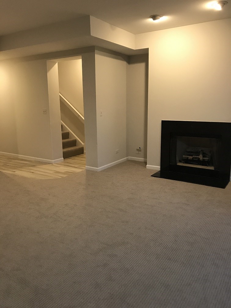 a living room with a fireplace and a carpeted floor