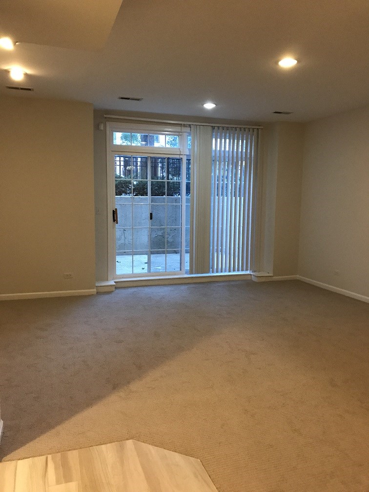 an empty living room with sliding glass doors to a patio