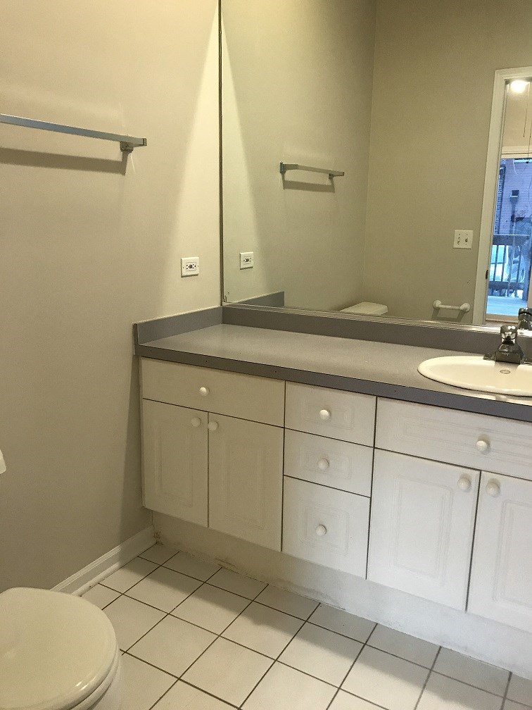 a bathroom with a toilet and a sink and a mirror