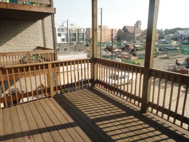 a balcony with a wooden railing and a view of a city