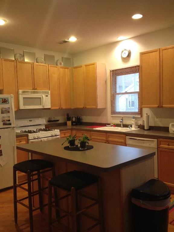 a kitchen with a center island with three bar stools