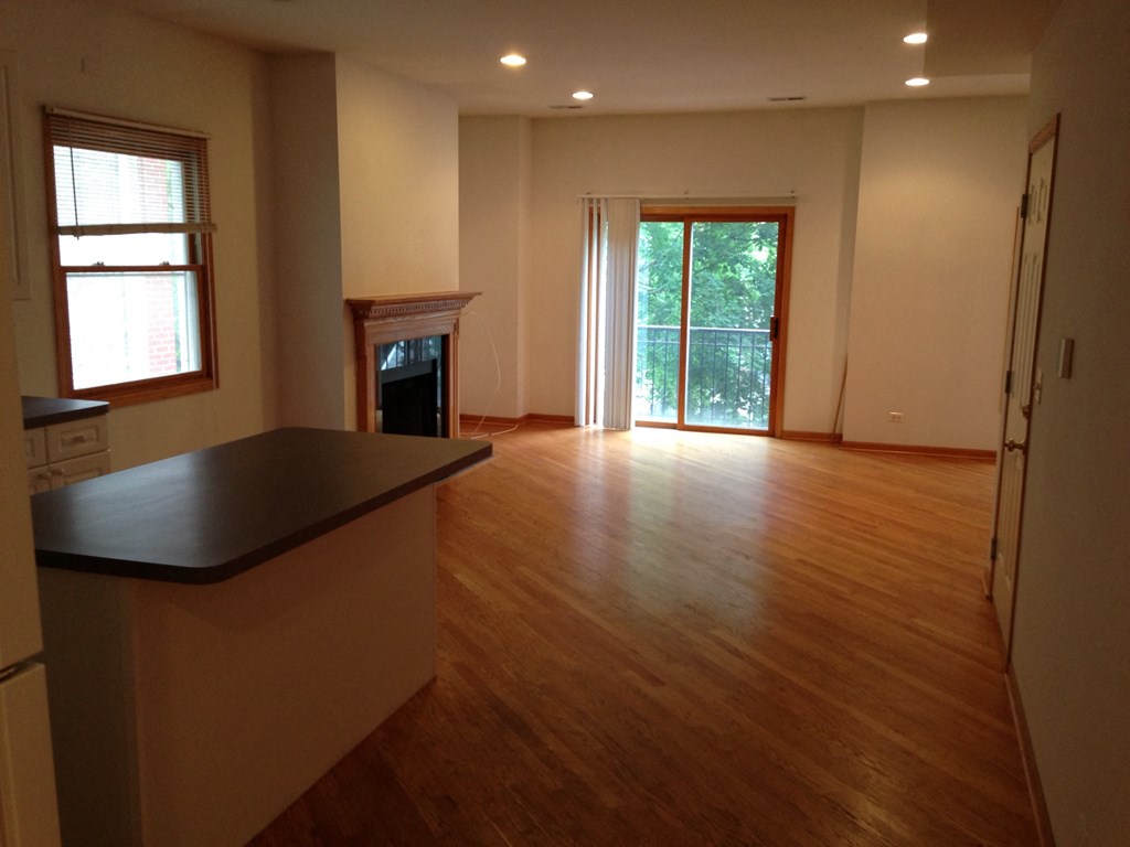 an empty living room with wood floors and a fireplace