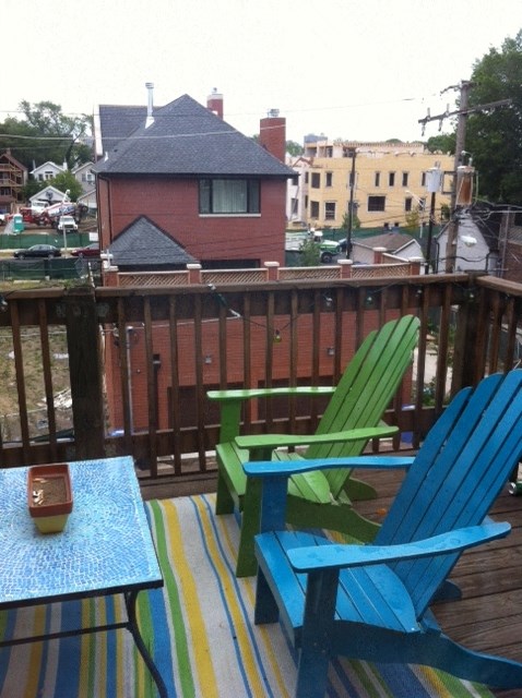 a deck with two chairs and a table on it