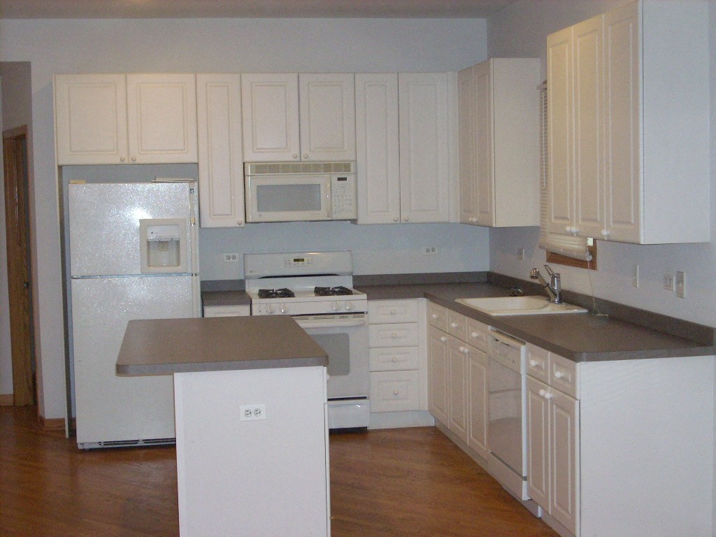 a white kitchen with white appliances and white cabinets