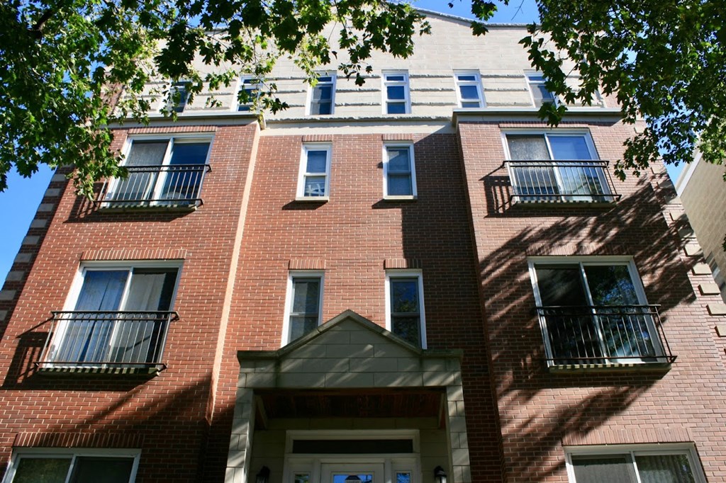 a red brick apartment building with blue windows and balconies