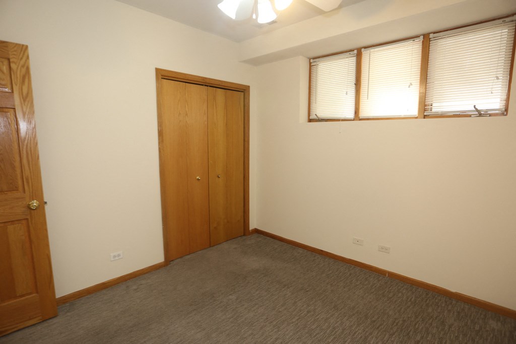 an empty room with a door and two windows