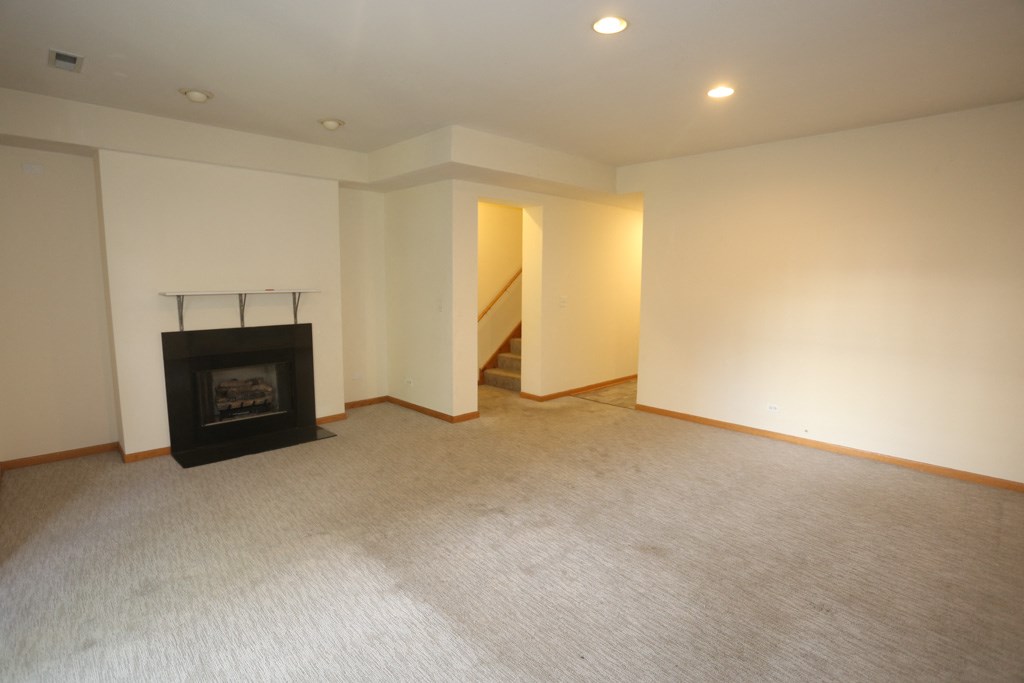 a empty living room with a fireplace and white walls