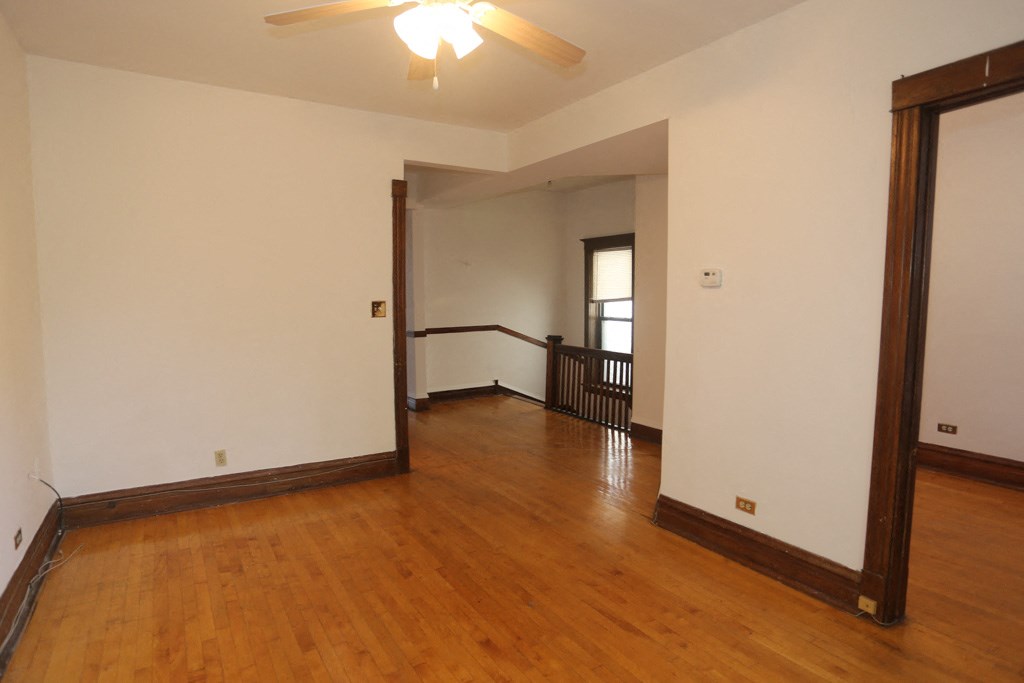 an empty living room with wood floors and white walls