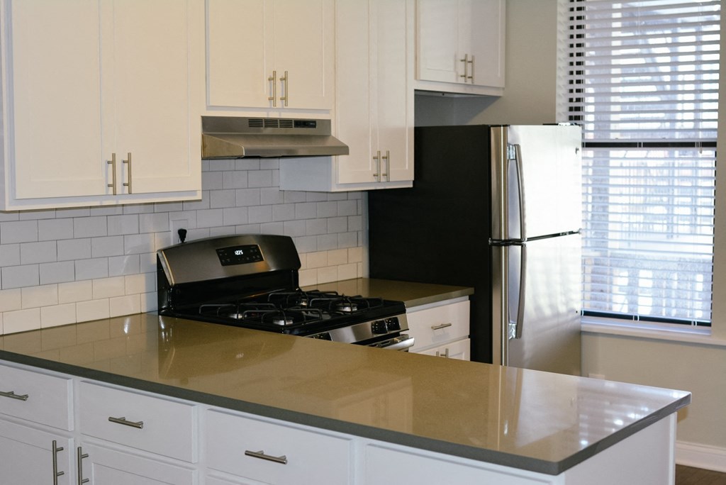 a kitchen with white cabinets and a black stove and refrigerator