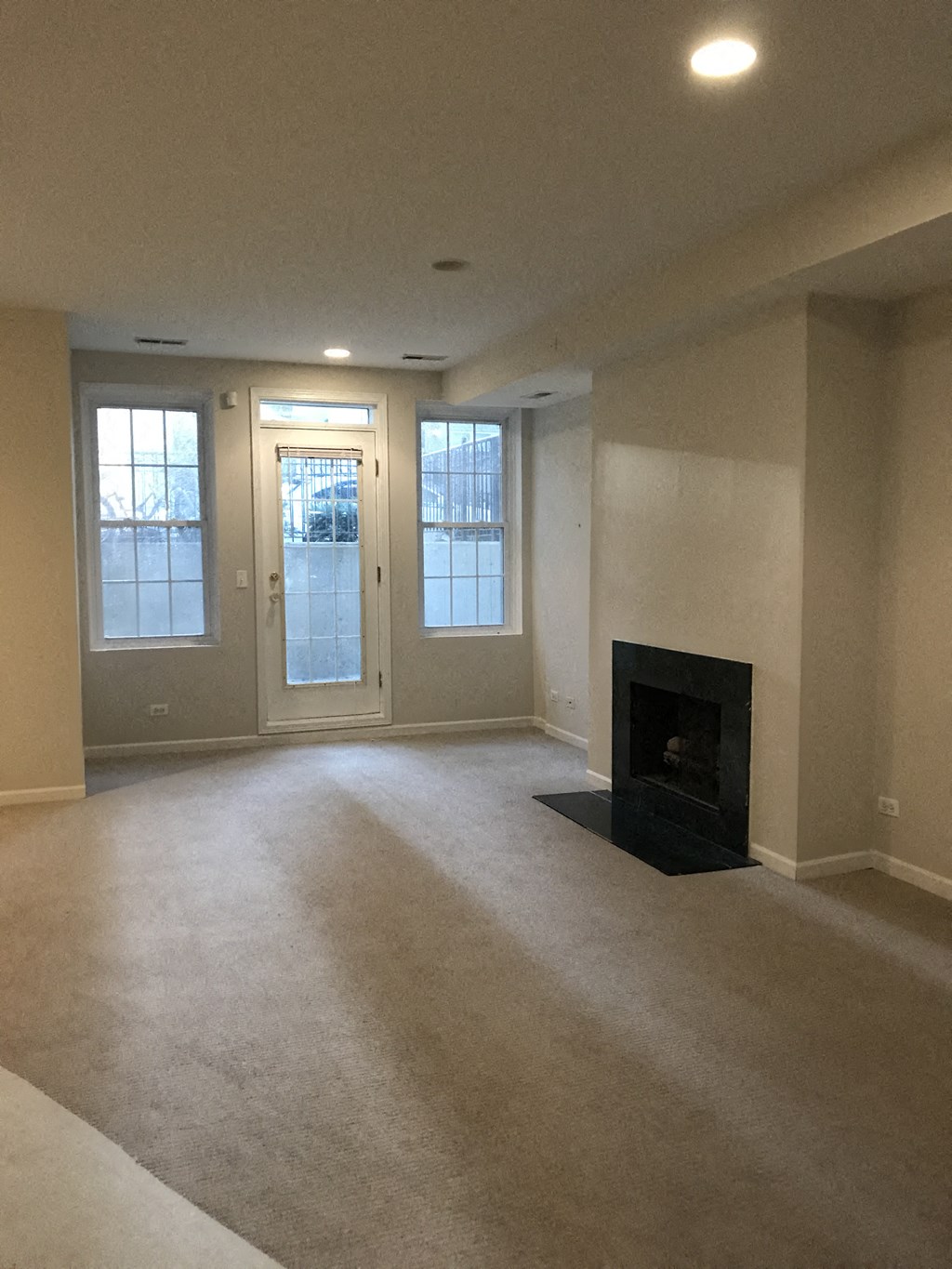 an empty living room with a fireplace