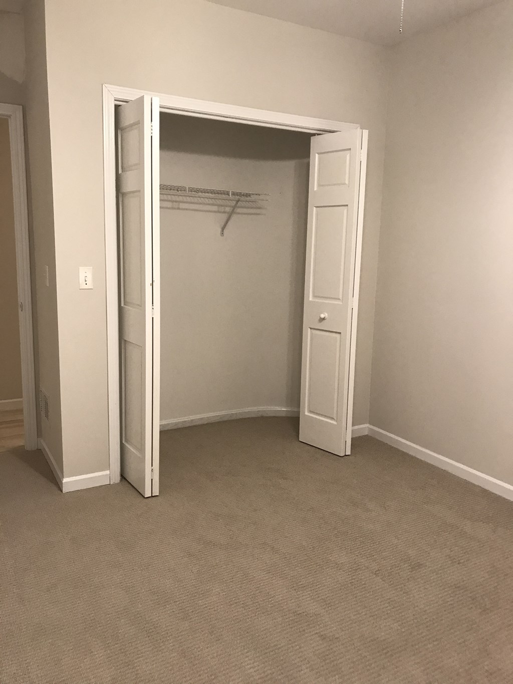 an empty room with a closet and an open door