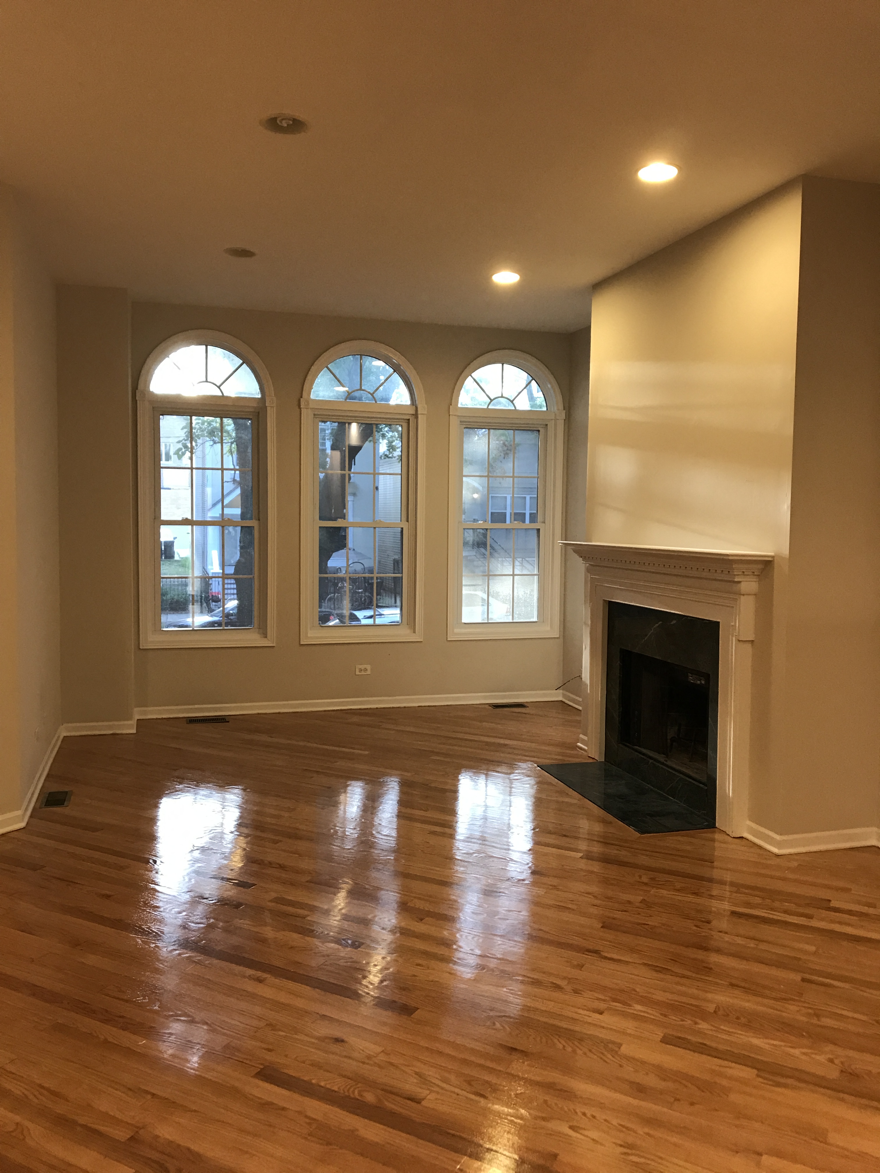 an empty living room with wood floors and a fireplace