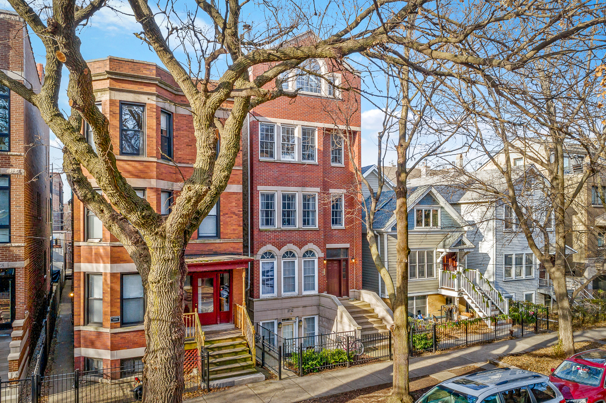 a row of houses on a city street with trees