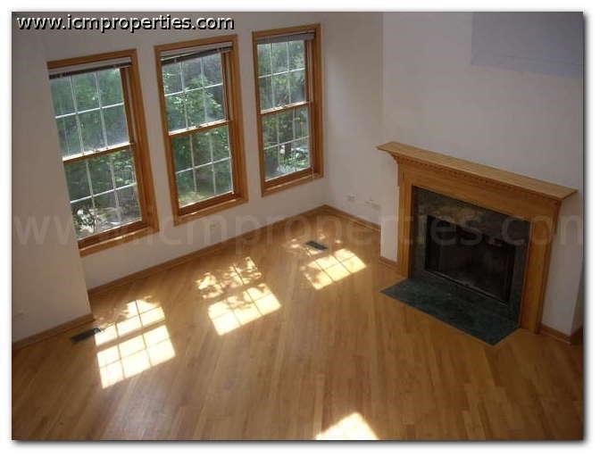 a living room with a wood floor and a fireplace