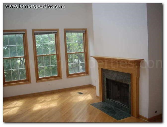 a empty living room with a fireplace and windows