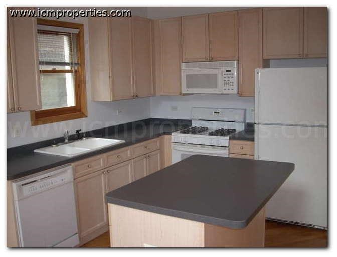 a kitchen with white appliances and a black counter top