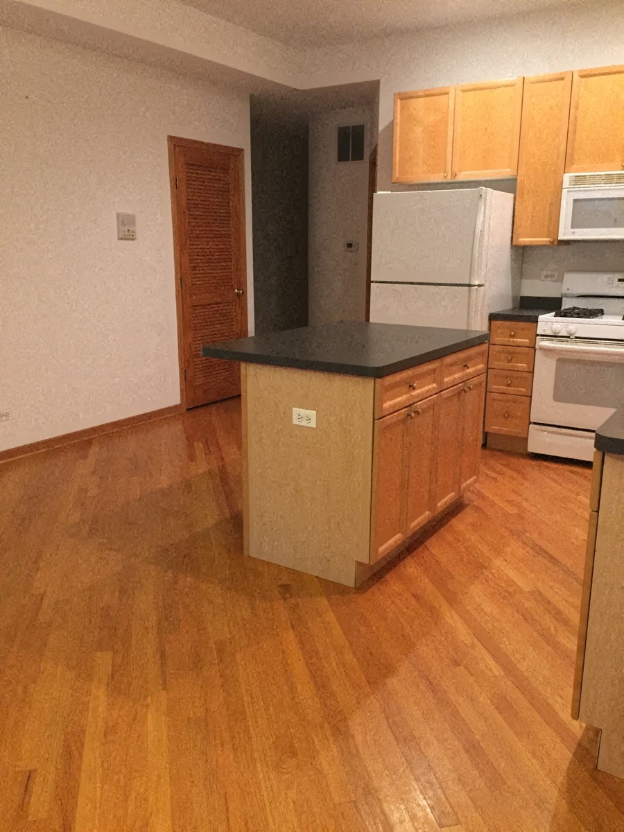 an empty kitchen with a counter top in the middle