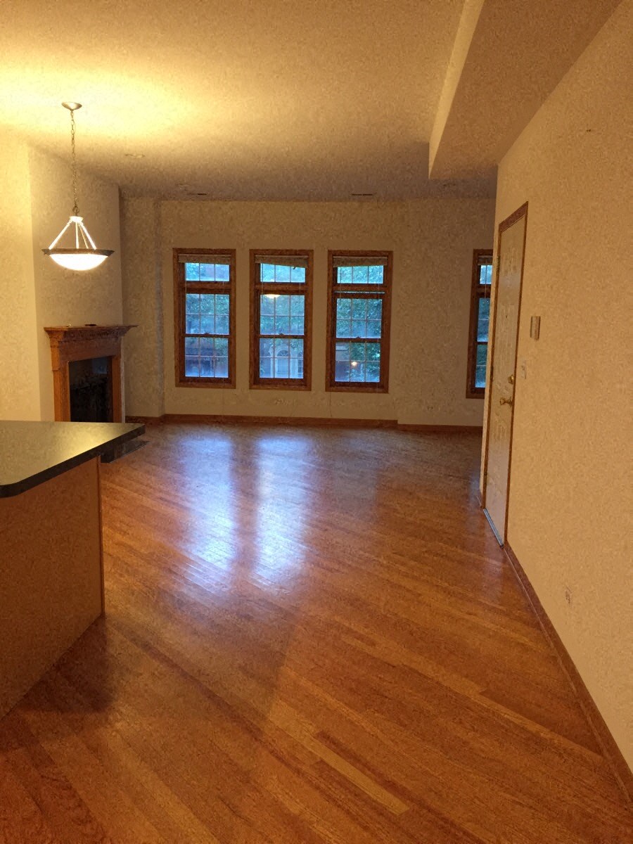 an empty living room with a wood floor and a fireplace